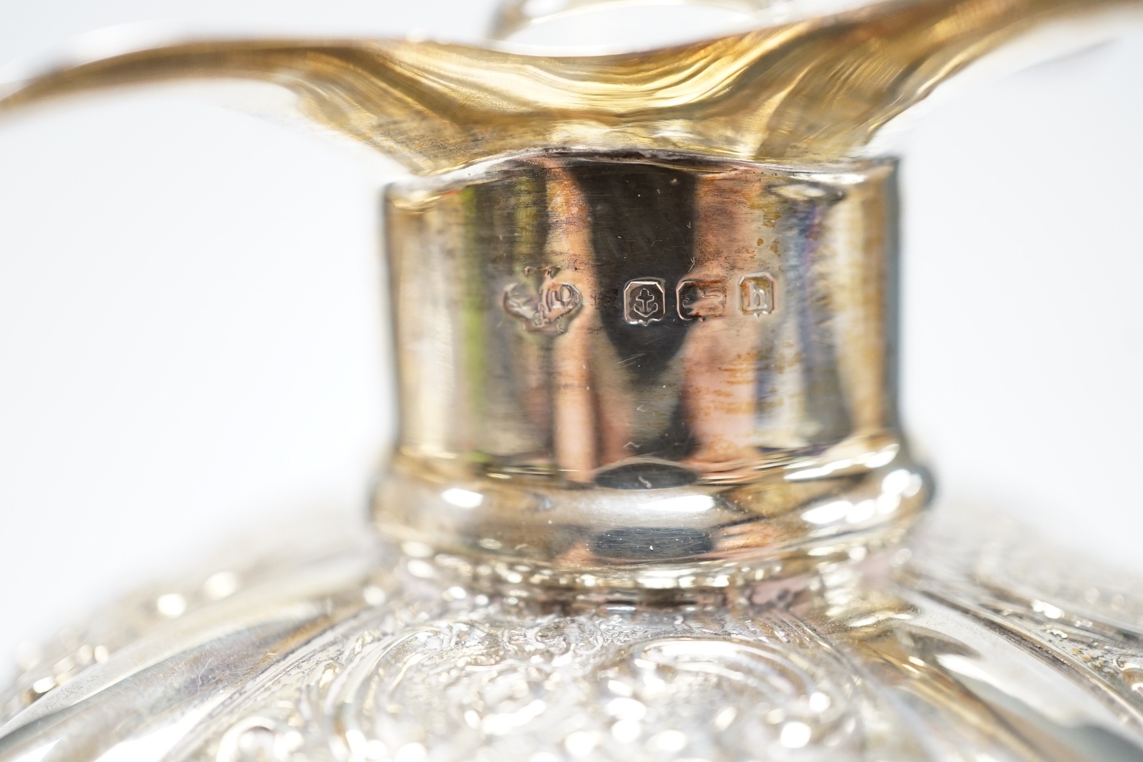 A pair of Edwardian silver mounted glass hour glass shaped decanters, William Hutton & Sons, Birmingham, 1906/7, with associated stoppers, height 23.9cm.